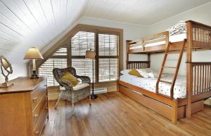 a bedroom with two bunk beds and a desk at Chalet 9023 Chemin des Alpages by Les Chalets Alpins in Stoneham