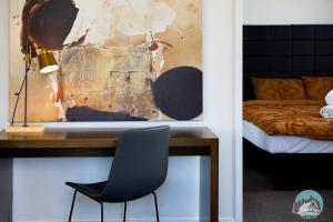 una scrivania con sedia in una camera con un letto di Aircabin - Chatswood - Walk to station - 2 Beds Apt a Sydney
