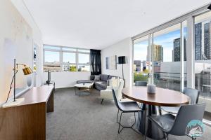 un soggiorno con tavolo, sedie e divano di Aircabin - Chatswood - Walk to station - 2 Beds Apt a Sydney