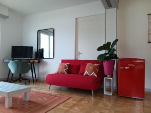 a red couch in a living room with a red refrigerator at La plus belle vue du lac Léman in Montreux