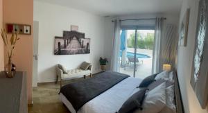 a bedroom with a bed and a balcony with a pool at VILLA NATURISTE JO&SPA ANNA'BELLA Luxury Suites "naturist couples only" in Cap d'Agde