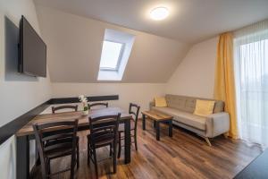 een woonkamer met een tafel en een bank bij Apartmány na Bukovce - GG in Červená Voda