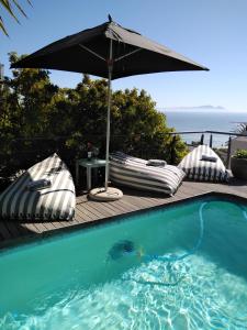 高登灣的住宿－Chocolate Box Guesthouse，一个带遮阳伞和桌子的游泳池