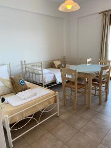 um quarto com uma mesa e cadeiras e uma cama em κοχυλι 3 em Armenistis