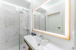 a white bathroom with a sink and a mirror at Bel Mare 210C by Renters in Międzyzdroje