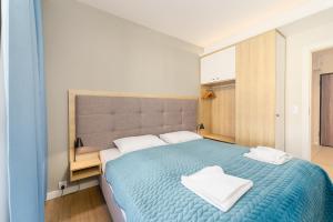 a bedroom with a blue bed with two towels on it at Bel Mare 210C by Renters in Międzyzdroje