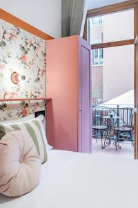 a bedroom with a bed and a balcony with a table at Hotel Espana - Gruppo BLAM HOTELS in Rome