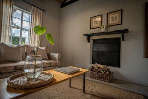 uma sala de estar com uma mesa com um vaso sobre ela em Saronsberg Vineyard Cottages em Tulbagh