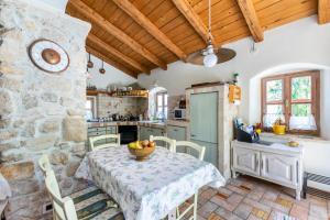 cocina con mesa y pared de piedra en House Rada i Stanisav, en Mošćenička Draga