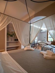 1 dormitorio con 1 cama grande y cortinas blancas en Locanda dei Sette Limoni en Vada