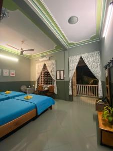 a bedroom with a blue bed and a fireplace at Trại Hoa Vàng Homestay at Tuy Hòa Phú Yên in Ðông Tác (1)