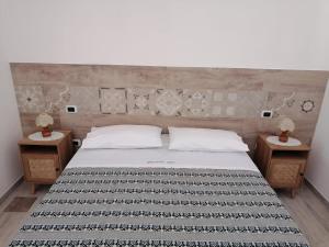 ein Schlafzimmer mit einem großen Bett mit zwei Nachttischen in der Unterkunft Agriturismo "PIRASTRERI" in Siniscola