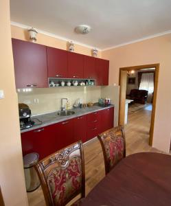 una cocina con armarios rojos y una mesa con sillas. en Green House, en Virpazar