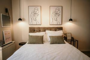 a bedroom with a white bed with two pictures on the wall at Studio Stylish in Vodice