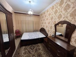 1 dormitorio con cama, espejo y tocador en Hanrapetutyan Apartment, en Ereván