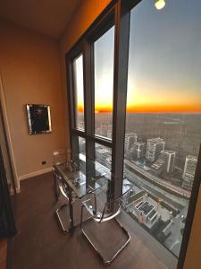 a glass table and chairs in a room with a large window at Skyland İstanbul + 42 plus in Istanbul