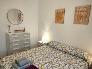 コニル・デ・ラ・フロンテーラにあるPuertacaiのベッドルーム1室(ベッド1台、ドレッサー、鏡付)