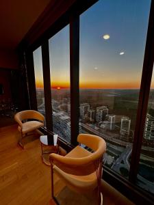 a room with two chairs and a large window at Skyland İstanbul + 42 plus in Istanbul