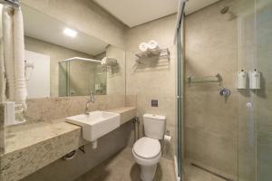 a bathroom with a toilet and a sink and a shower at Hotel Laghetto Rio Grande in Rio Grande