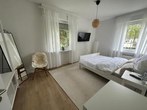 a white bedroom with a bed and a desk at Comfort Corner at Campus Birkenfeld in Hoppstädten-Weiersbach