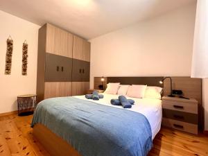 a bedroom with a large bed with two blue towels on it at Apartament Les 3 Valls in Llavorsí