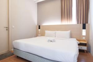 a bedroom with a large white bed with two towels on it at Swiss Garden Residence Bukit Bintang in Kuala Lumpur
