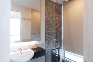 a bathroom with a sink and a shower with a mirror at Swiss Garden Residence Bukit Bintang in Kuala Lumpur