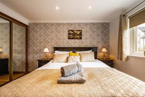 a bedroom with a large bed and two lamps at The Pink Bungalow in Dingwall