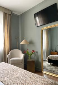 1 dormitorio con espejo, silla y cama en B&B Colombo, en Mestre