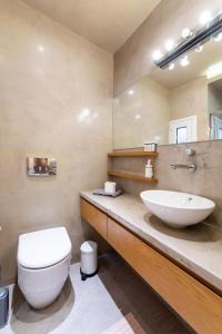 a bathroom with a sink and a toilet and a mirror at #Penelope by halu! apartments in Thessaloniki