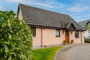 a brick house with a black roof at The Pink Bungalow in Dingwall