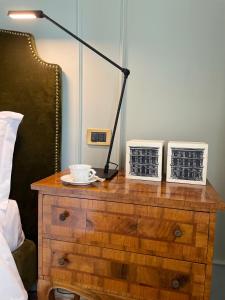 una mesa con una lámpara encima de un tocador junto a una cama en B&B Colombo, en Mestre