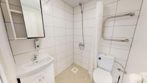 a white bathroom with a toilet and a sink at Kivi Apartments in Jõhvi