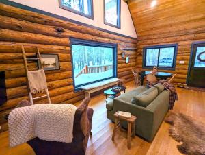 una sala de estar con sofá en una cabaña de madera en Firefly Cabin en West Glacier
