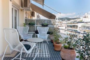 balcón con sillas, mesa y algunas plantas en #Penelope by halu! apartments en Tesalónica
