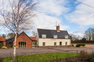 a white house with a black roof at The Plough in Wangford