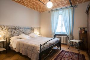 1 dormitorio con 1 cama grande y cortinas azules en La Giribaldina Winery & Farmhouse, en Calamandrana