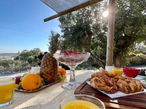una mesa con un plato de comida y un vaso de jugo de naranja en Pequeno Paraíso, 6 guests, São Brás de Alportel, en São Brás de Alportel
