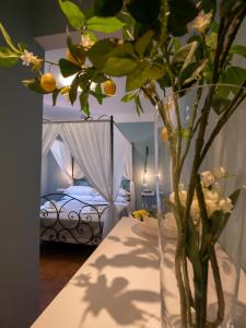 Locanda dei Sette Limoni في فادا: مزهرية مع الزهور على طاولة في غرفة النوم