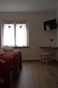 a room with a bed and two windows and a table at Agriturismo Quinta Essenza in Casoni Zanolla