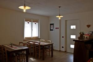 une salle à manger avec deux tables et des chaises ainsi qu'une fenêtre dans l'établissement Agriturismo Quinta Essenza, à Casoni Zanolla