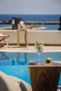 una copa de vino sentada en una mesa junto a una piscina en Valledi Village Hotel, en Kími