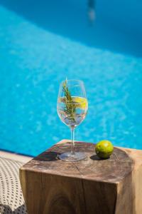 a wine glass sitting on a table next to a pool at Griffon Kymi Hotel previously known as Valledi Village in Kymi