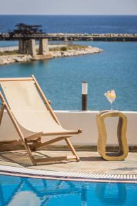 a lounge chair next to a swimming pool at Valledi Village Hotel in Kymi