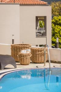 ein Pool mit Korbkörben neben einem Haus in der Unterkunft Valledi Village Hotel in Kími
