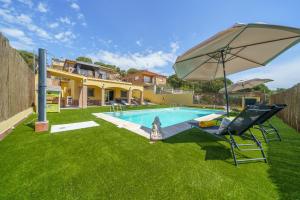 uma piscina com um guarda-sol e uma cadeira em Villa Denis Lux, Gran zona Exterior con Piscina em Lloret de Mar