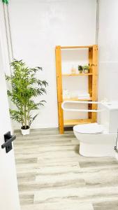 a bathroom with a toilet and a plant at Area Surf House in Muros +11 photos