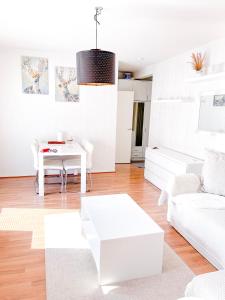 un soggiorno con divano bianco e tavolo di Ilona Apartments -"Home Away From Home" a Kotka