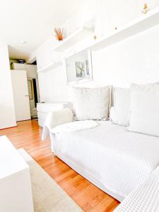 a white living room with a couch and wooden floors at Ilona Apartments -"Home Away From Home" in Kotka