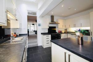 a kitchen with white cabinets and a black counter top at Remarkable 3-Bed House in Bath in Bath